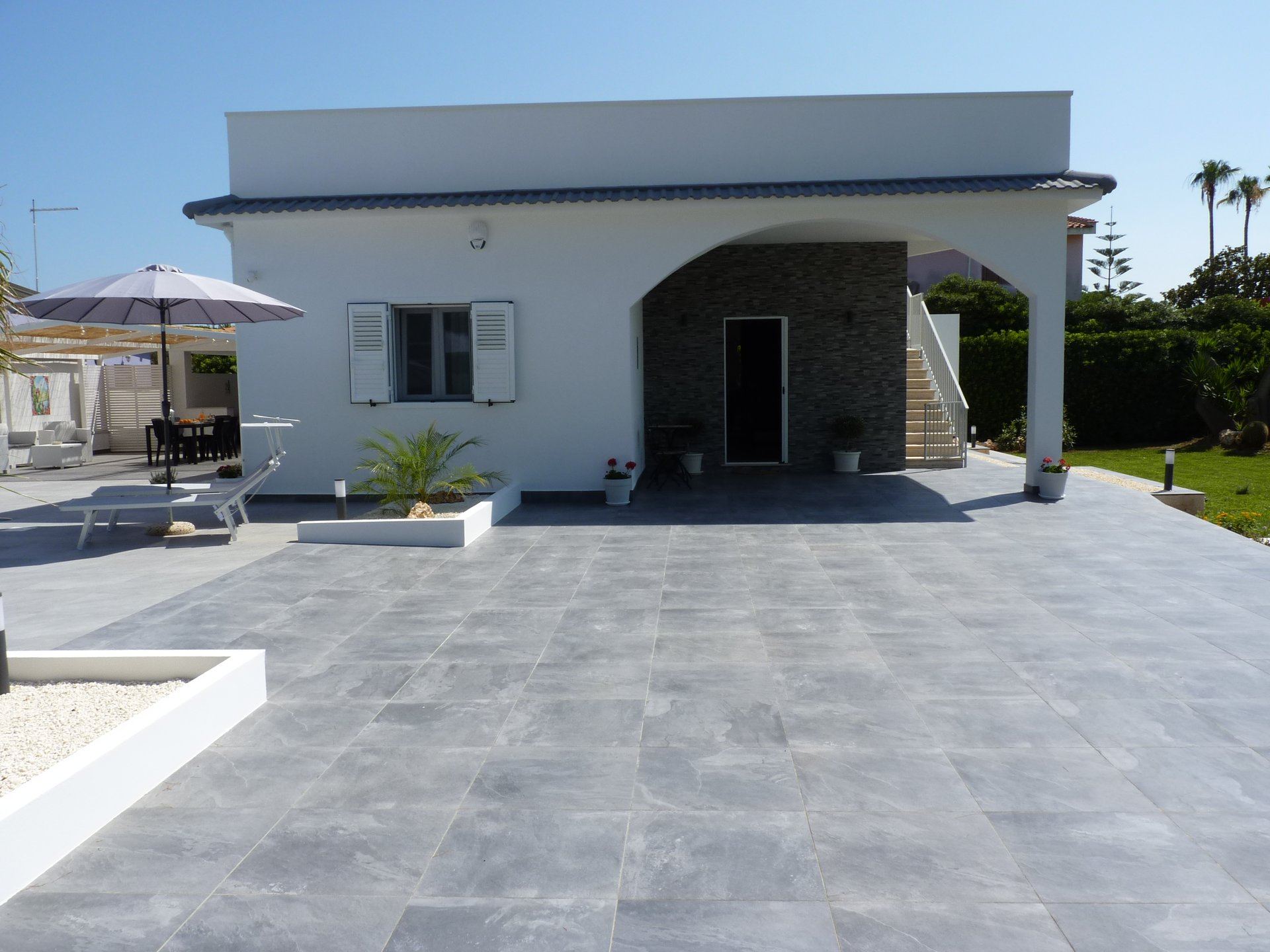 Villa Siciliu exterior surrounded by Mediterranean palms and greenery